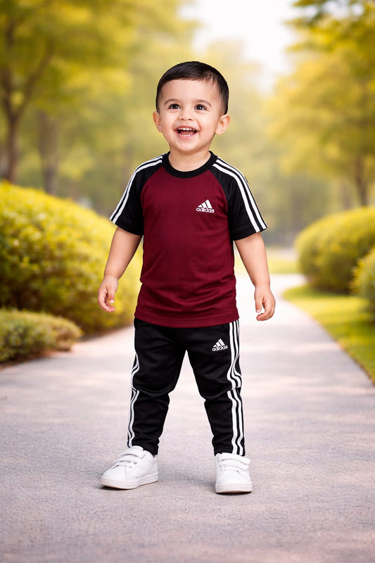 Kid's dry-fit tracksuit by Superwear in maroon and black, featuring comfortable athletic fabric and a sporty design.